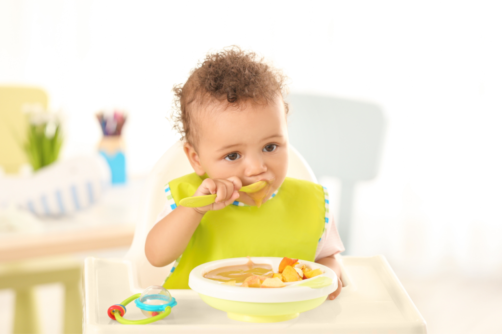 bébé qui mange son repas en toute autonomie, cuillère à la bouche, devant son assiette, consultation allaitement et alimentation, troubles de l'oralité Maine et Loire 49